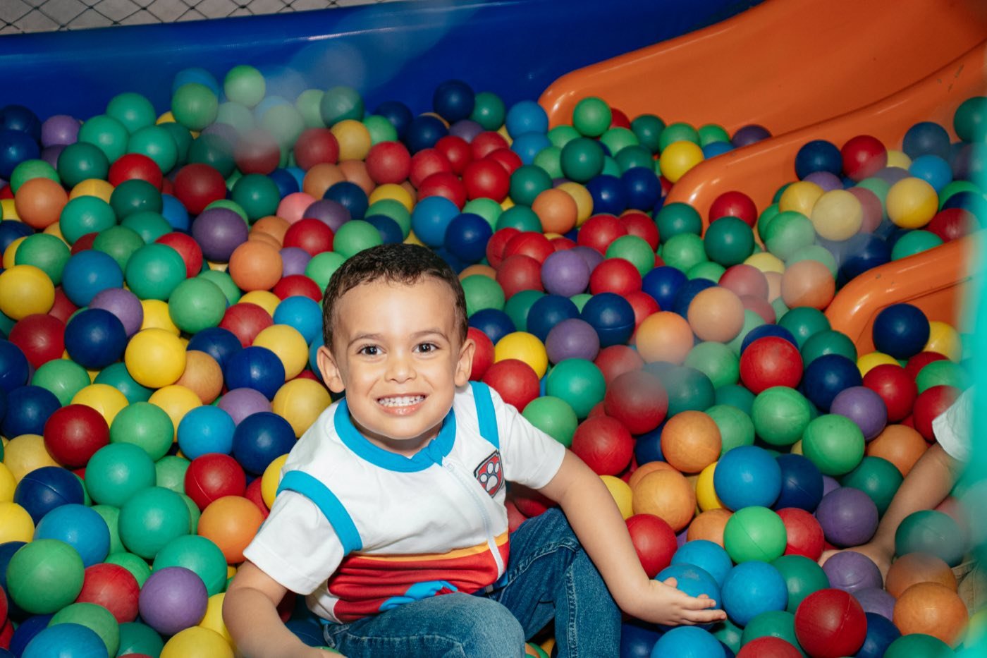 Criança brincando na piscina de bolinhas
