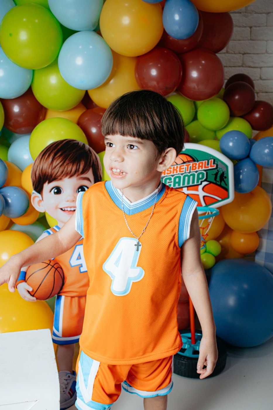 Menino com camisa de basquete entre balões