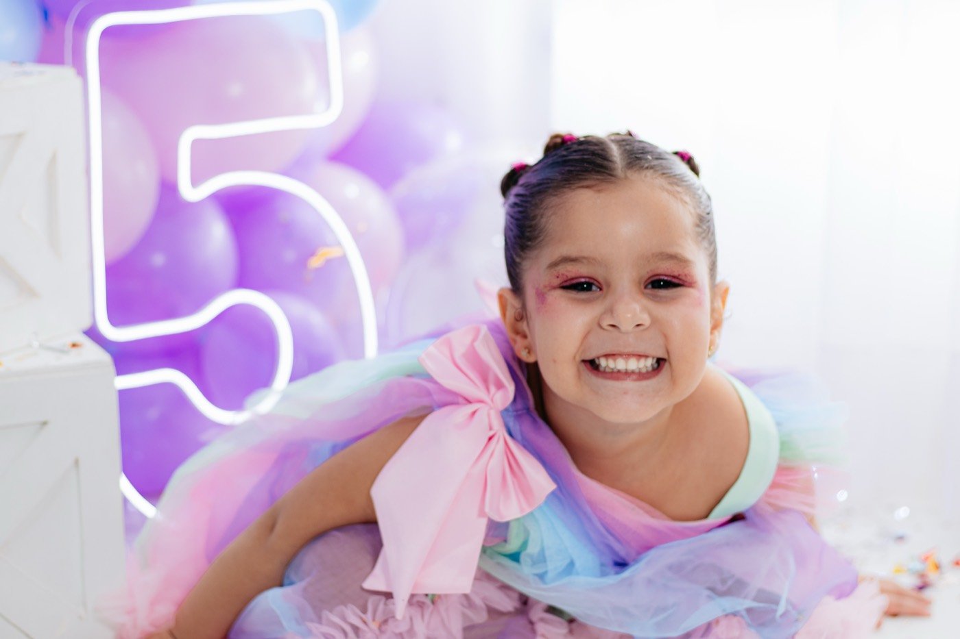 Menina sorrindo em frente ao número iluminado