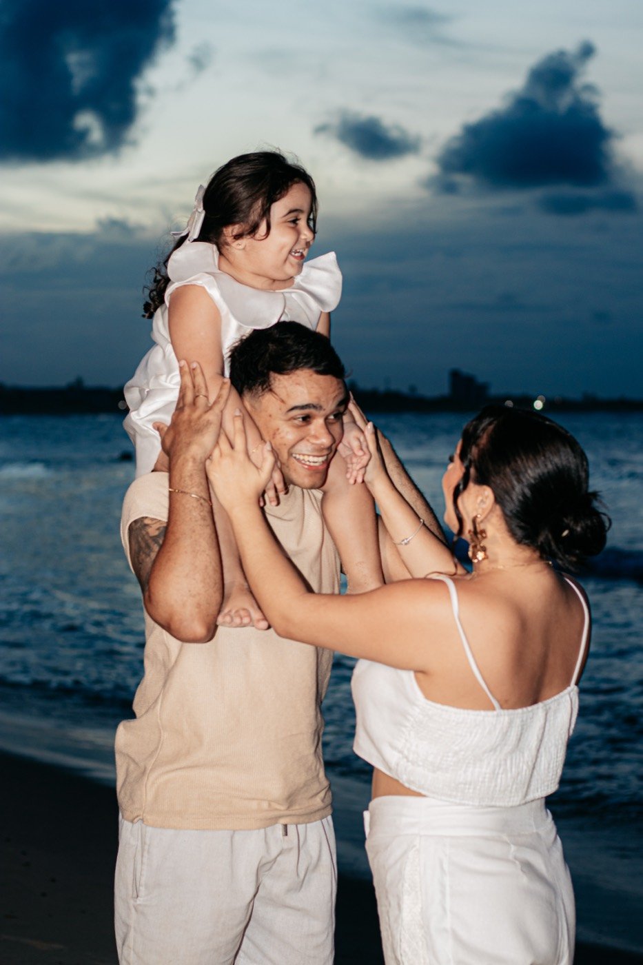 Família na praia ao pôr do sol